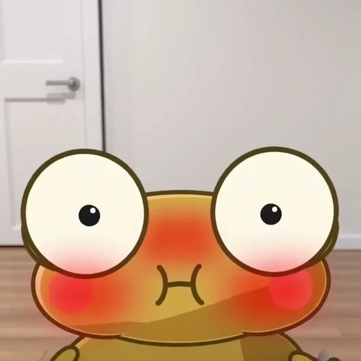 Golden Kero with huge eyes blushes bright red with puffed out cheeks, in front of a white door and a wooden floor.